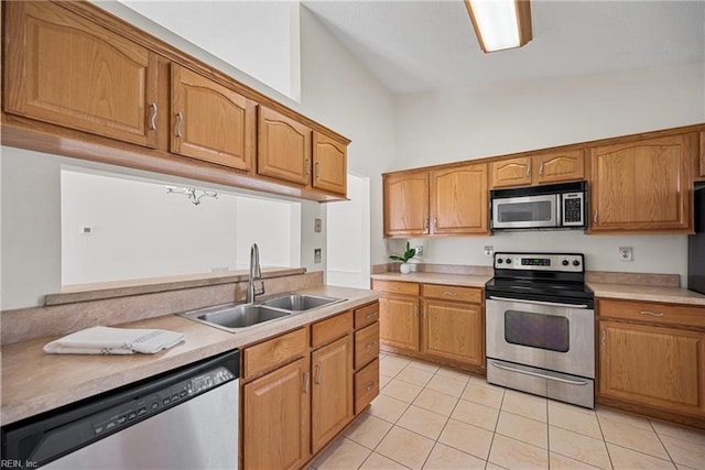 kitchen with high vaulted ceiling, stainless steel appliances, sink, and light tile patterned floors