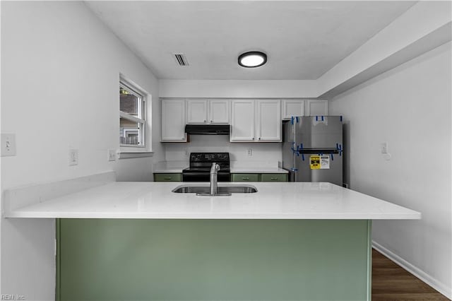 kitchen featuring sink, black electric range oven, stainless steel fridge, dark hardwood / wood-style flooring, and kitchen peninsula