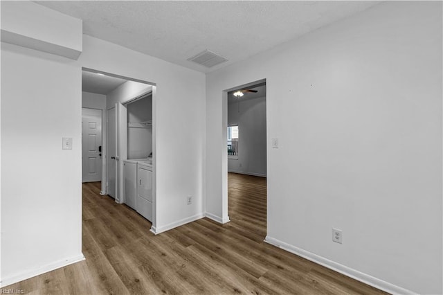 interior space with washer and clothes dryer, wood-type flooring, and ceiling fan