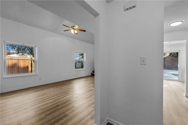 unfurnished living room featuring ceiling fan, lofted ceiling, and light hardwood / wood-style floors