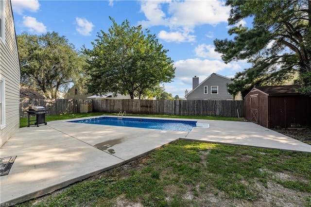 view of swimming pool featuring a patio, grilling area, and a shed