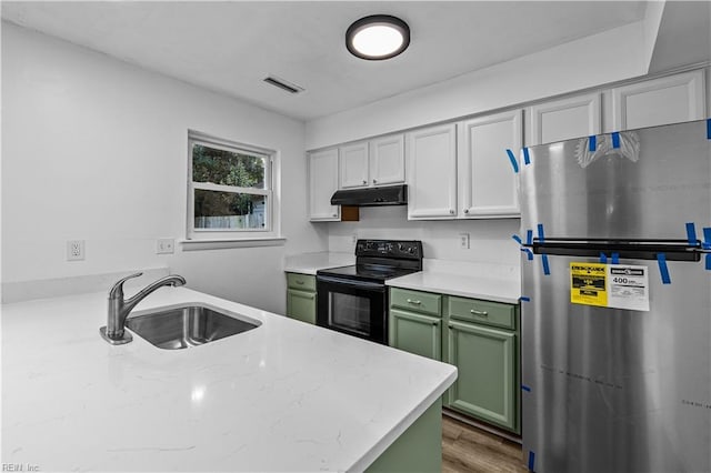 kitchen with hardwood / wood-style floors, sink, stainless steel fridge, green cabinetry, and black / electric stove