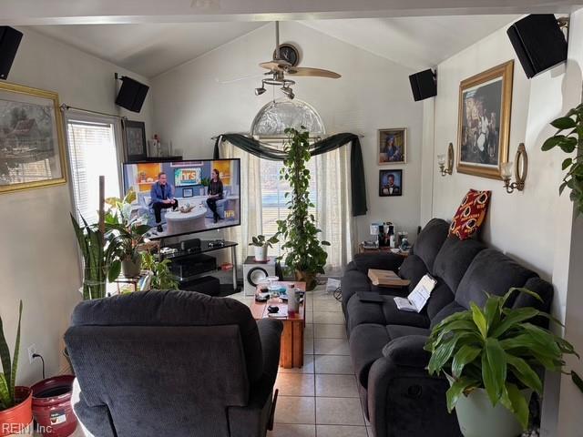 tiled living room featuring lofted ceiling with beams and ceiling fan