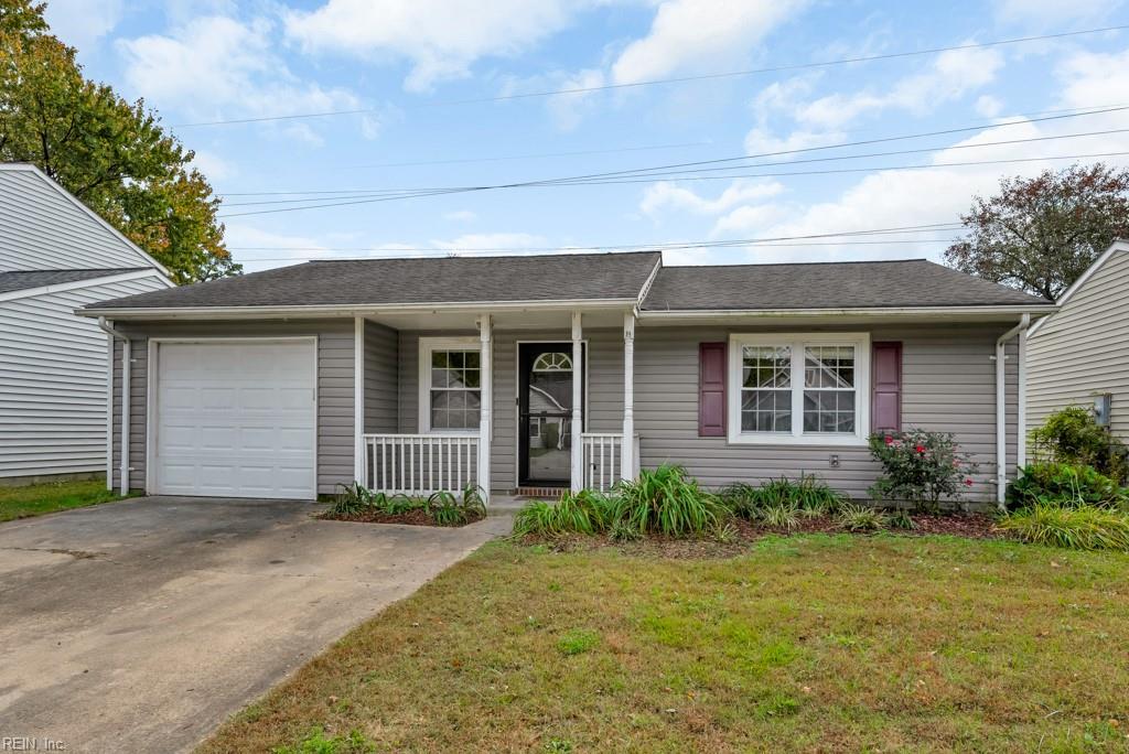 ranch-style home with a garage, a porch, and a front lawn