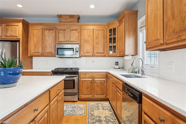 kitchen with sink, stainless steel appliances, and light hardwood / wood-style floors