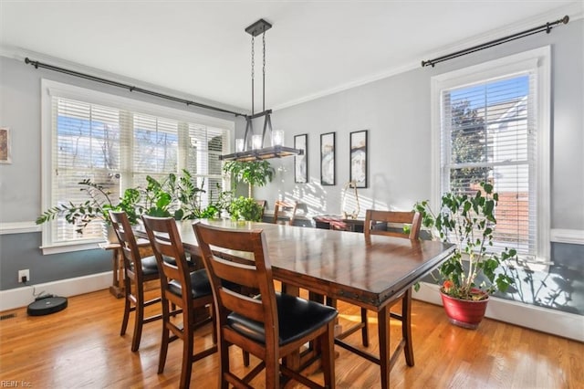 dining room featuring light hardwood / wood-style flooring and ornamental molding