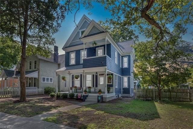 victorian home with covered porch and a front yard