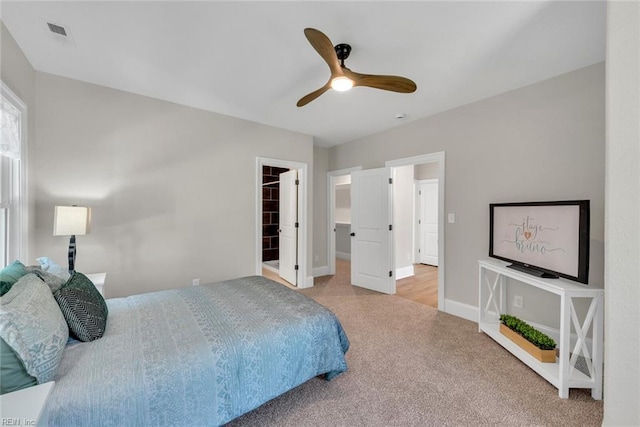 bedroom featuring a spacious closet, light carpet, ceiling fan, and a closet