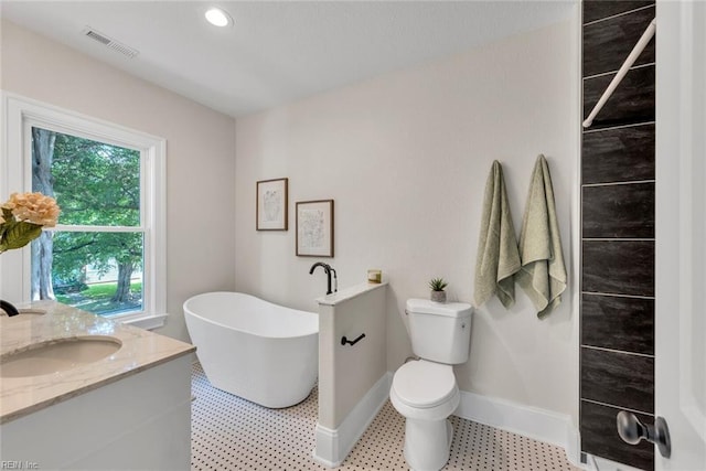 bathroom featuring vanity, a washtub, and toilet