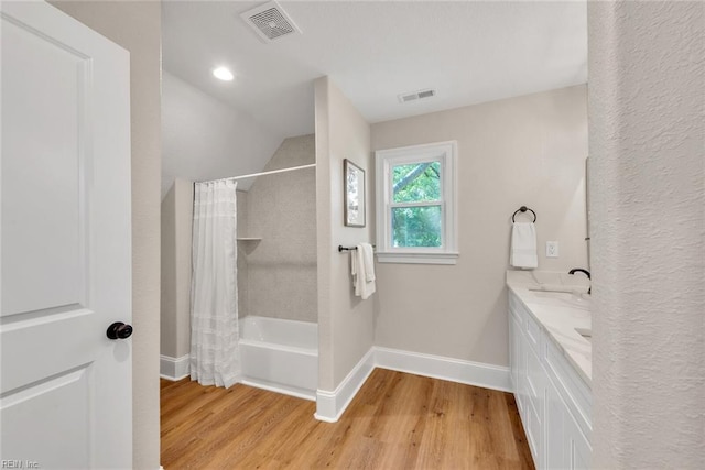 bathroom featuring shower / bathtub combination with curtain, hardwood / wood-style floors, and vanity