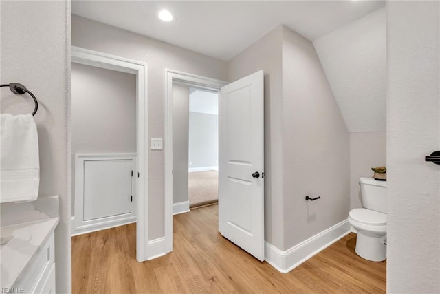 bathroom featuring lofted ceiling, toilet, and hardwood / wood-style floors