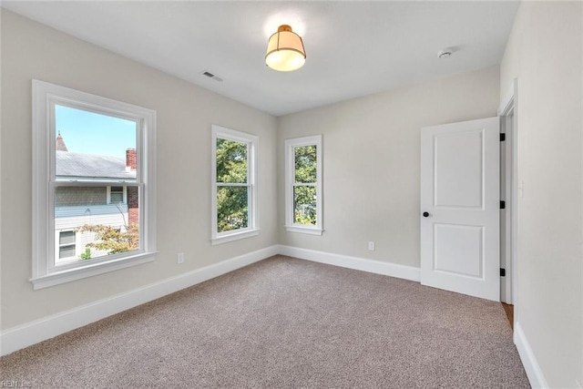 carpeted empty room featuring plenty of natural light