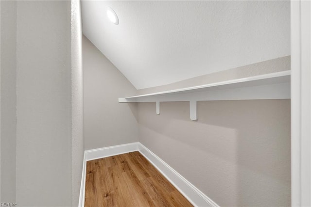 walk in closet featuring lofted ceiling and hardwood / wood-style flooring