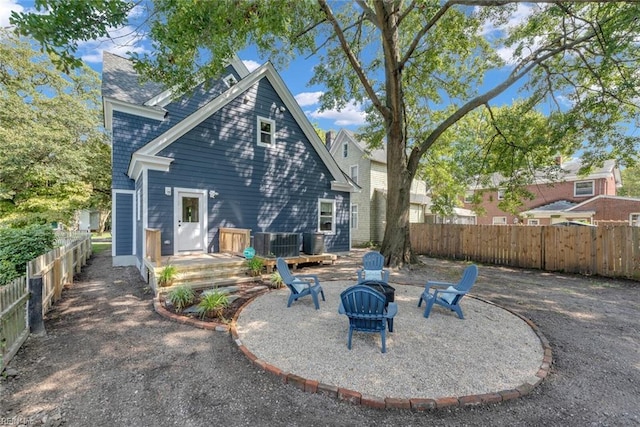 back of property with a fire pit and central air condition unit