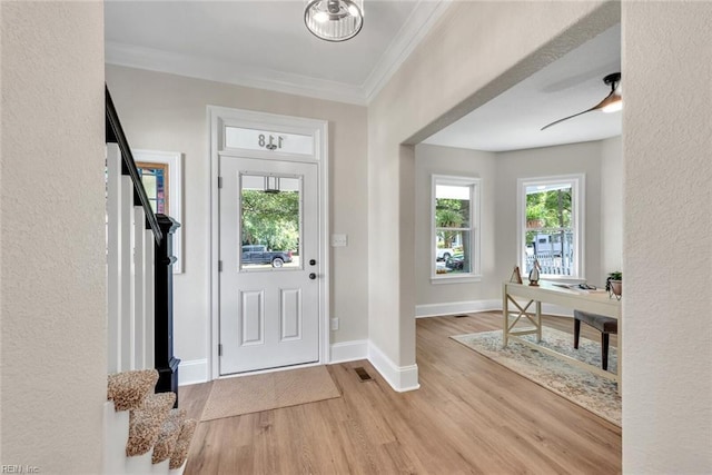 entrance foyer with crown molding, ceiling fan, and light hardwood / wood-style floors