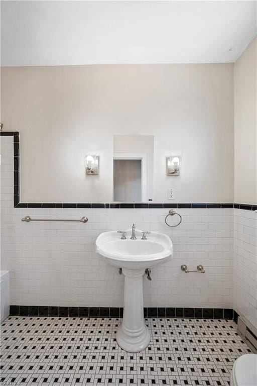 bathroom featuring toilet, tile patterned flooring, and tile walls