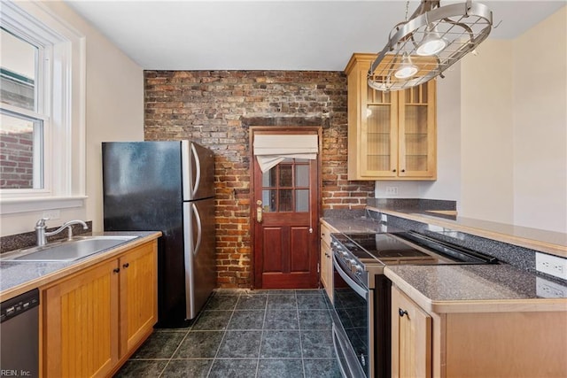 kitchen featuring brick wall, stainless steel appliances, and sink