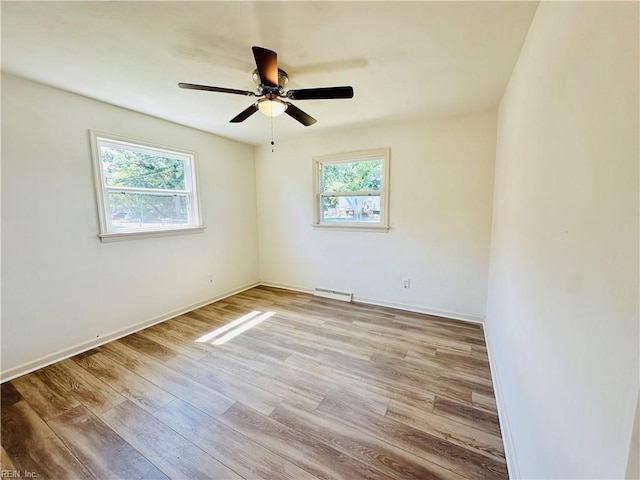 empty room with ceiling fan and light hardwood / wood-style floors