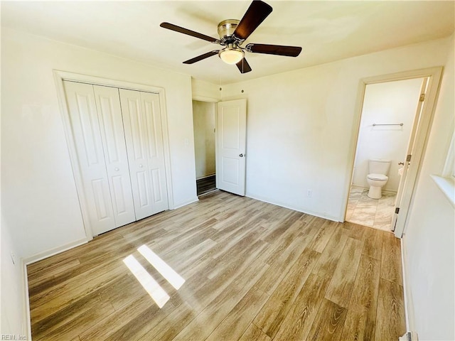 unfurnished bedroom with ceiling fan, a closet, ensuite bath, and light hardwood / wood-style flooring