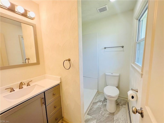 bathroom with vanity, a shower, and toilet