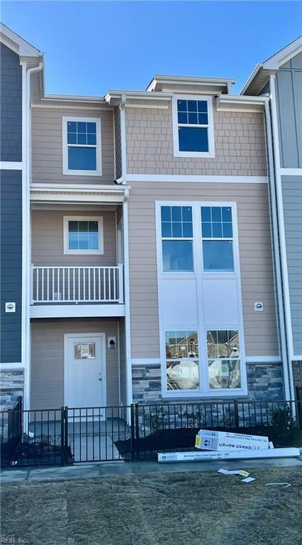 view of property featuring a fenced front yard and stone siding