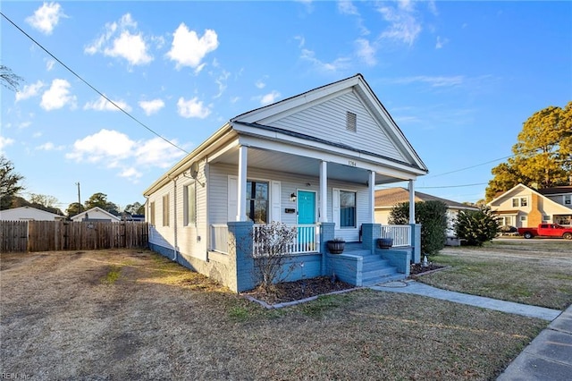 view of front of property featuring covered porch and fence