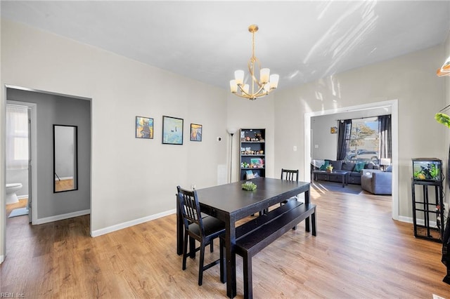 dining area with a notable chandelier and light hardwood / wood-style flooring