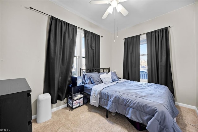 carpeted bedroom with ceiling fan and multiple windows