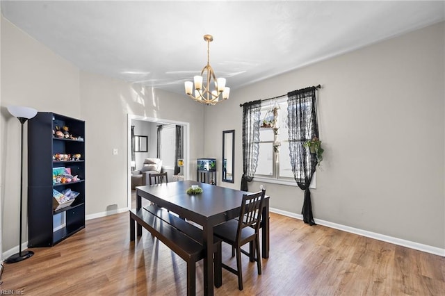 dining space featuring an inviting chandelier and hardwood / wood-style floors