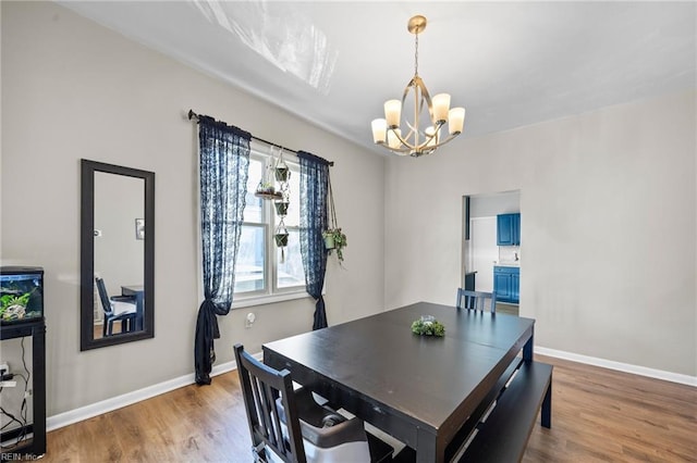 dining room with hardwood / wood-style floors and an inviting chandelier