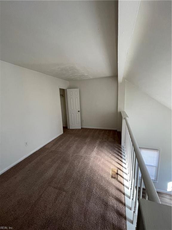 carpeted spare room with lofted ceiling