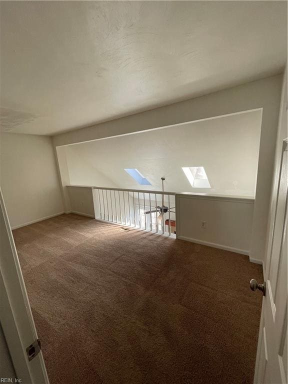 empty room featuring a skylight and carpet floors