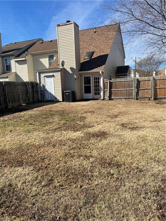 rear view of house with a yard and central AC unit