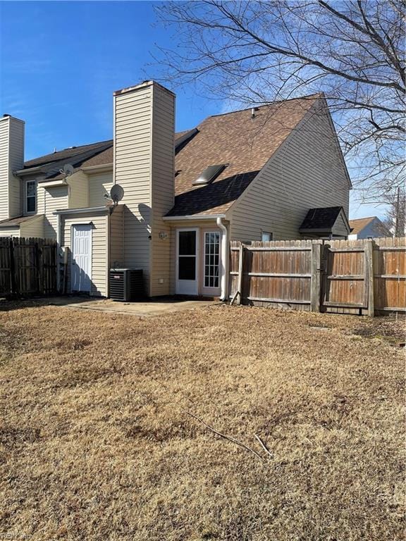 rear view of property with a yard and central air condition unit