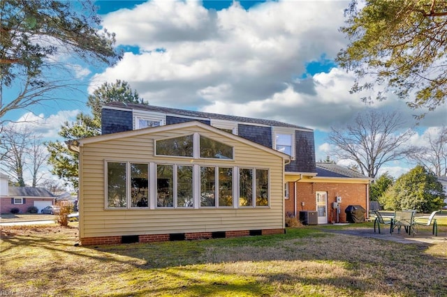 rear view of house featuring cooling unit, a yard, and a patio