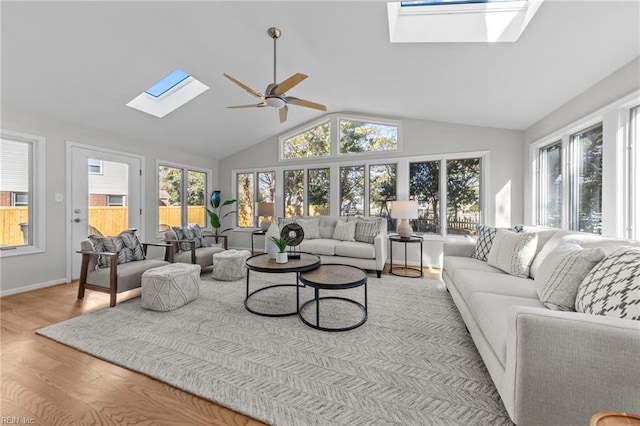 sunroom featuring lofted ceiling with skylight, a healthy amount of sunlight, and ceiling fan