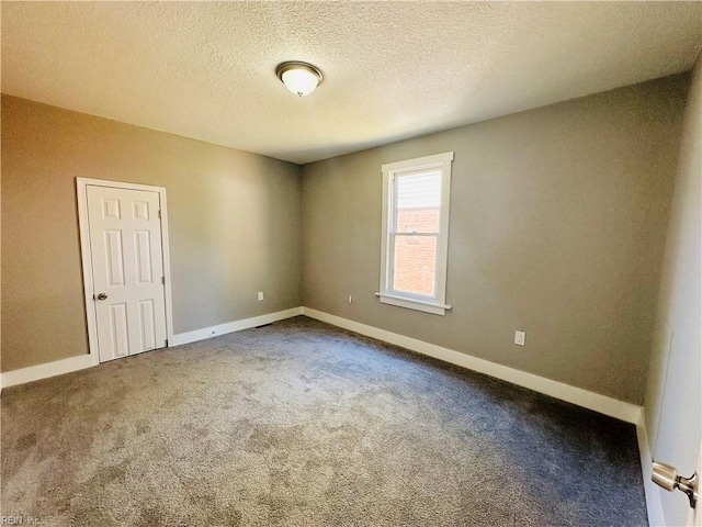 carpeted spare room featuring a textured ceiling