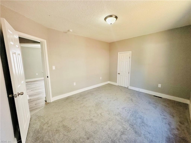 carpeted spare room with a textured ceiling