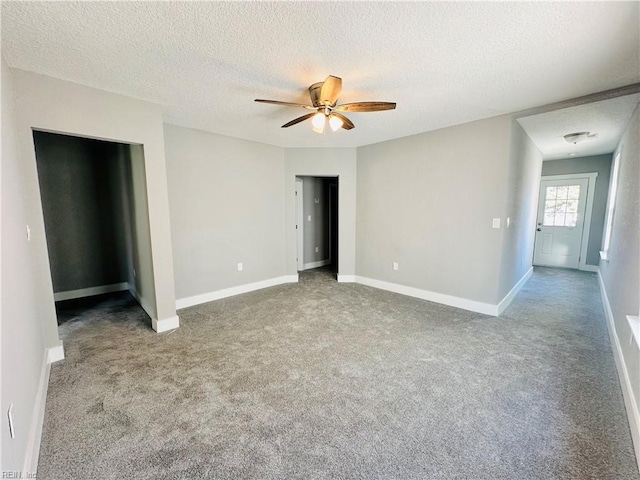 unfurnished bedroom featuring ceiling fan, light carpet, and a textured ceiling