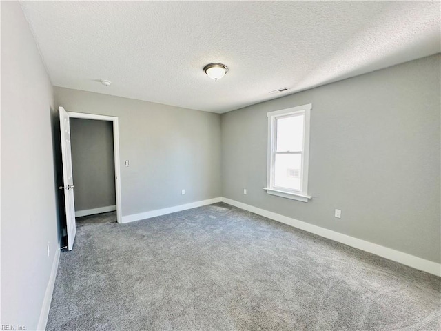 unfurnished room with carpet floors and a textured ceiling