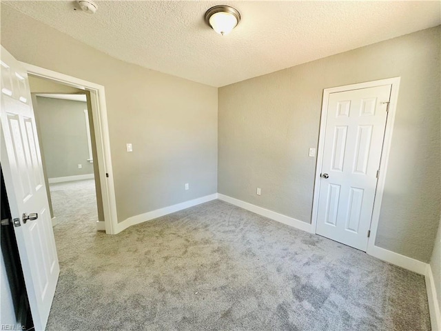 carpeted empty room with a textured ceiling