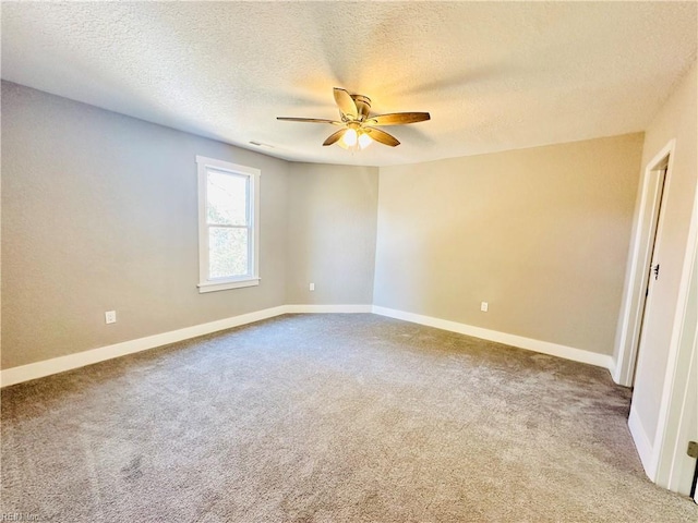 carpeted spare room with a textured ceiling and ceiling fan