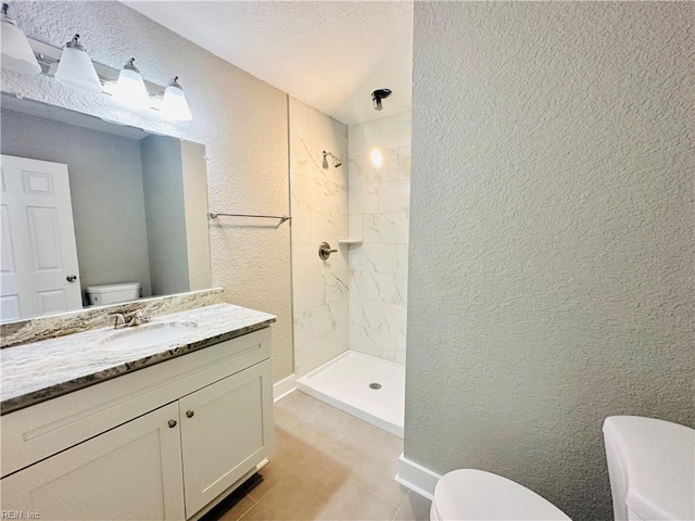 bathroom featuring vanity, toilet, and tiled shower