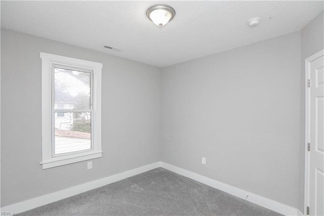 carpeted spare room with a textured ceiling