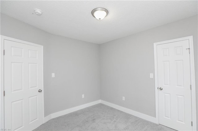 carpeted spare room with a textured ceiling