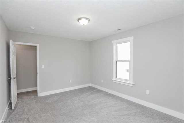 spare room featuring light colored carpet