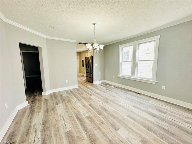 unfurnished dining area featuring ornamental molding, a textured ceiling, and light hardwood / wood-style flooring