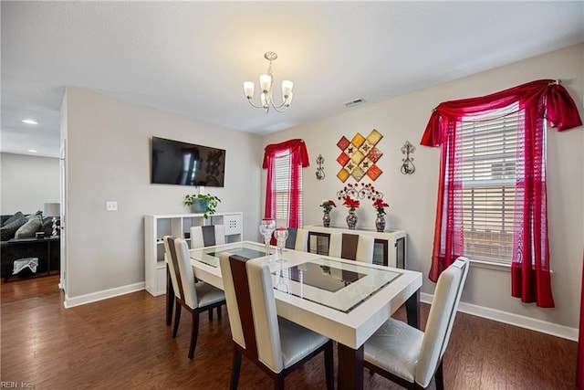 dining area featuring a notable chandelier and dark hardwood / wood-style floors