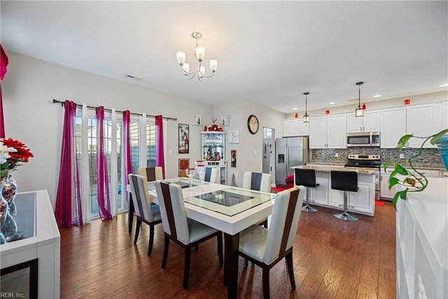 dining area with dark hardwood / wood-style floors and a notable chandelier