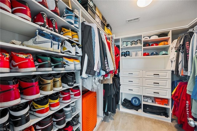 walk in closet featuring light carpet